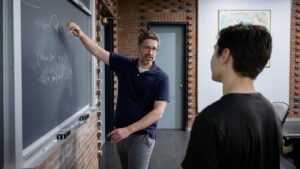 David Cash showing an equation to a student